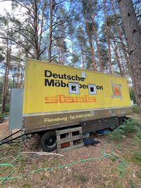 Unpainted tiny house on a trailer in the forest