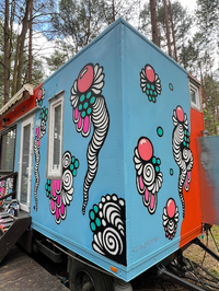 Painted tiny house with detailed artwork on its side